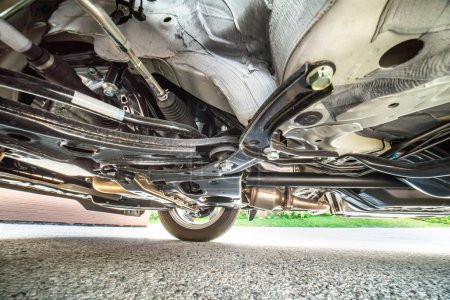 Téléchargez les photos : Bottom car view for safety inspection. Concept of garage services, used vehicle appraisal, car points inspection, automobile certification. Checking on shock absorbers damaged and suspension parts. - en image libre de droit