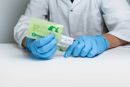 Photo for Toronto, Ontario, Canada - December 30, 2022: Male nurse holding Covid 19 Rapid test kit given to shoppers at grocery stores and pharmacies across the province. Rapid antigen test package kit. - Royalty Free Image