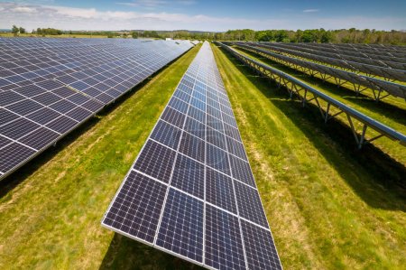 Téléchargez les photos : Vue des panneaux solaires se tient dans une rangée. Innovation énergétique verte. Panneaux électriques sur le terrain. Écologie dans la nature et technologies respectueuses de l'environnement réduisant l'empreinte carbone. - en image libre de droit