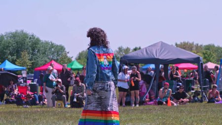 Téléchargez les photos : Une personne avec un drapeau à deux esprits sur le dos. Pow wow Danse traditionnelle autochtone. 2-Spirit Powwow, par les 2-Spirited People of the 1st Nations. Célébration : Toronto, Ontario, Canada - 27 mai 2023. - en image libre de droit