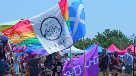 Photo for Display of flags at Two Spirits Pow wow. Pride flag with 2-Spirited Native American symbol. Iroquois Confederacy flag and Metis flag: Toronto, Ontario, Canada - May 27, 2023. - Royalty Free Image