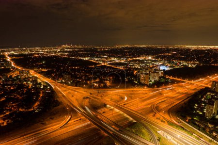 Photo for Top view deep night city of car traffic at intersection lane and buildings. Long exposure of urban cityscape. Modern city life in Canada, moving cars, trucks and buses. - Royalty Free Image