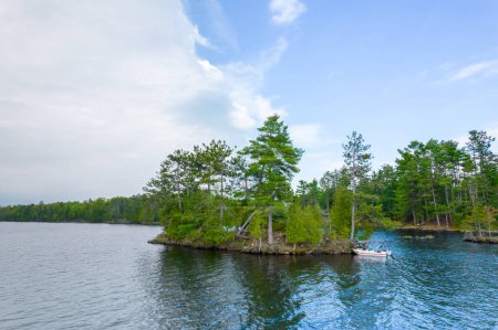 Seitenansicht eines Schlauchbootes mit Elektromotor, das in der Wildnis des Sees verankert ist. Sommertag und Freizeit am See. Perfekte Frühjahrsaktivität für ruhige Erholung in der Natur vom städtischen Stress. 