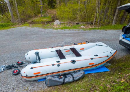 Inflatable PVC boat catamaran for fishing and hunting preparation. Vacation and leisure. Inflatable dinghy vessel or air-filled craft pontoon with electric motor and lithium battery.