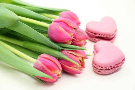 Photo for Bouquet of fresh pink tulips with heart-shaped macroons close-up. - Royalty Free Image