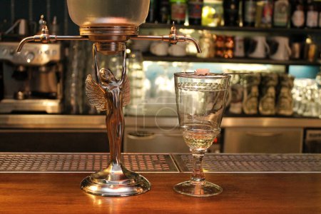 Photo for Absinth fountain and glass with spoon on bar counter close-up. - Royalty Free Image