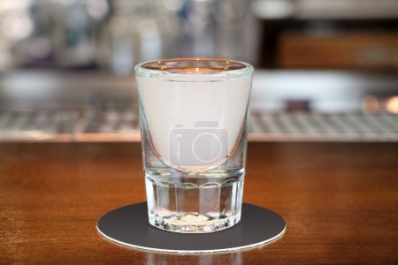 Photo for Ouzo or raki - traditional balkan anise strong alcoholic drink on bar counter close-up. - Royalty Free Image