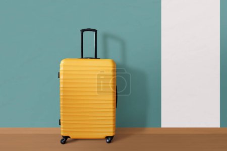 Photo for New yellow suitcase against the wall. Travel and vacation concept. - Royalty Free Image