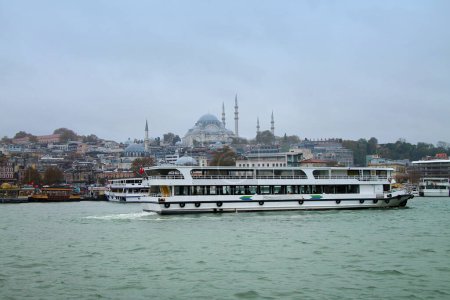 Vista de la mezquita Yeni Cami desde el Puente de Galata. Estrecho del Cuerno de Oro con barco turístico. Estambul, Turquía.