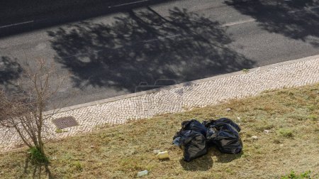 Müllsack neben einer Straße liegen gelassen, was zu Umweltverschmutzung in der Stadt führt 