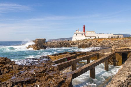 Scenic view of the cabo raso lighthouse with waves crashing on rocky coast in cascais, portugal