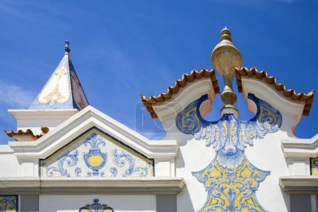Téléchargez les photos : Un fragment du toit du bâtiment décoré avec des tuiles portugaises traditionnelles dans le style Azulejo sur le fond du ciel bleu. - en image libre de droit