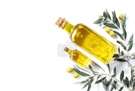 Photo for Two glass bottles of olive oil and sprigs of olive tree are on a white background. View from the top point. Copy space. - Royalty Free Image