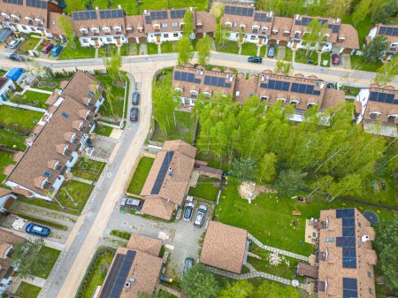 Aerial drone image of some pretty houses  with solar panels on the roofs reducing CO2 emissions for a better environment.