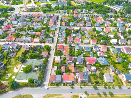 Luftaufnahme von warmen, sonnigen Nachbarschaftsdächern mit diagonalen Straßen und vielen Häusern mit Pools und Palmen.