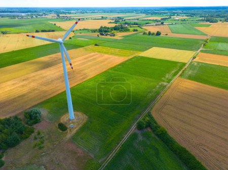 Aerial view of powerful Wind turbine farm for energy production on beautiful cloudy sky at highland. Wind power turbines generating clean renewable energy for sustainable development.