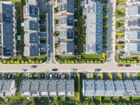Téléchargez les photos : Vue aérienne du quartier des maisons résidentielles et du complexe d'immeubles d'appartements au coucher du soleil. Maisons serrées, allée entoure flyve arbre vert. Développement immobilier de banlieue - en image libre de droit