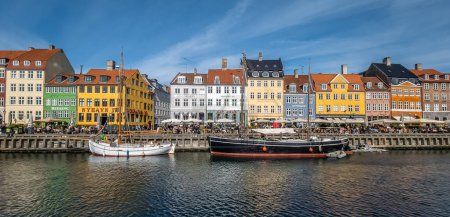 view of Nyhavn a 17th-century waterfront, canal and entertainment district in Copenhagen, Denmark. Lined by bright colored 17th and early 18th century townhouses