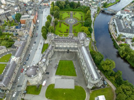 Foto de Vista aérea del castillo de Kilkenny, remodelación victoriana de una estructura defensiva medieval, parque rodante, jardín de rosas en terrazas, bosques, lago artificial junto al río Nore - Imagen libre de derechos