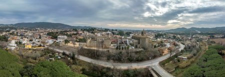 Aerial view of Calonge town and medieval castle with inner garrison courtyard surrounded by walls with crenallations and quare old tower, residential palace. Used as a venue for music festival in Catalonia Spain