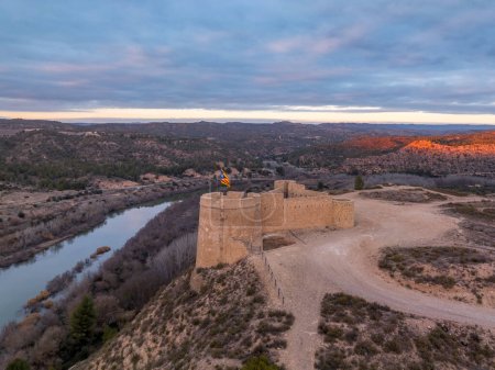 Foto de Cielo colorido aéreo puesta del sol vista panorámica de Flix nuevo castillo sobre el río Ebro en España con plataformas de pistola circular de forma triangular - Imagen libre de derechos