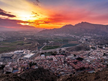 Aerial view of Orihuela in Murcia province Spain medieval town with castle and Gotchic and Baroque churches near the Segura river with dramatic colorful sunset sky