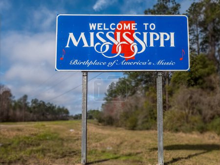 Téléchargez les photos : En bref Bienvenue à Mississippi panneau d'entrée de l'état de la route avec fond flou - en image libre de droit