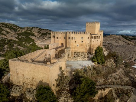 Vue aérienne du château de Velez Blanco sur une colline et une ville avec des maisons d'un ou deux étages murs blanchis à la chaux et des toits carrelés avec un ciel nuageux spectaculaire en Andalousie Espagne