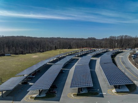Foto de Filas de paneles solares alimentando un estacionamiento de energía verde - Imagen libre de derechos