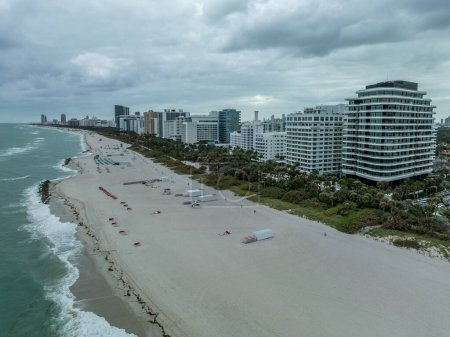 Aerial view of South Beach hotels and high rise apartment complexes prime real estate properties in Miami near the ocean with cloudy sky