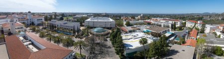 Aerial panorama view of San Diego State University, accredited public higher education institution with centennial plaza, aztec student union, health and human sciences college, love library, rooftop with solar panels