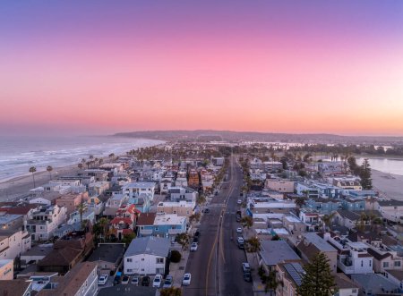 Téléchargez les photos : Vue aérienne du ciel coloré levant du soleil sur Mission Beach San Diego avec des maisons de vacances résidentielles, villas avec personne dans la rue - en image libre de droit