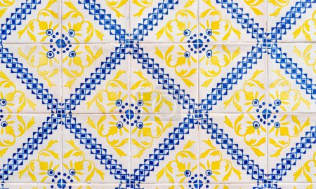 Téléchargez les photos : Fragment de mur de construction avec des carreaux muraux en céramique jaune et bleu Azulejo Abstrait motif décoratif décoratif texturé. Architecture traditionnelle portugaise ornée - en image libre de droit