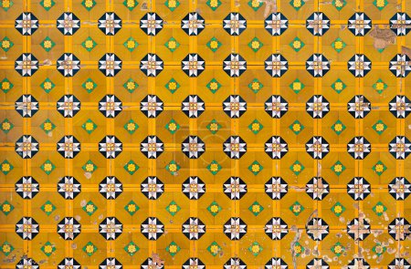Téléchargez les photos : Fragment de mur de construction avec carreaux muraux en céramique jaune floral Azulejo Abstrait fond décoratif motif décoratif texturé. Architecture traditionnelle portugaise ornée - en image libre de droit