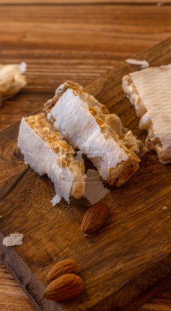 Photo for Close-up of Almond Spanish turron dessert slices with nuts on on wooden desk - Royalty Free Image