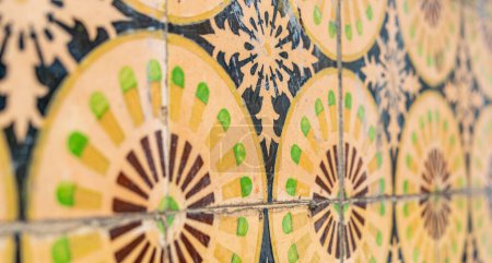 Téléchargez les photos : Gros plan sur le mur de l'ancien bâtiment avec des carreaux muraux floraux jaunes en céramique Azulejo Abstrait fond décoratif motif décoratif texturé. focus sélectif - en image libre de droit