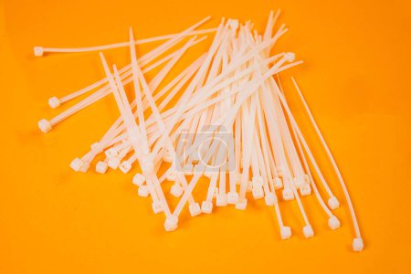 Photo for Nylon cable ties in glass in jar in bucket on orange background front top view isolated - Royalty Free Image