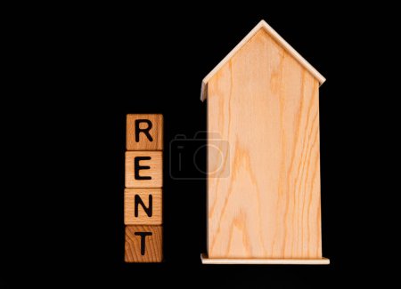 Téléchargez les photos : Maquette de maison en bois avec clés de maison, cubes en bois avec mots louer vente, achat et prêt. Projet pour designer sur fond noir - en image libre de droit