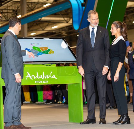 Téléchargez les photos : Madrid, Spain- January 18, 2023: The King and Queen of Spain and the president of the Andalusian Autonomous Community at FITUR. King Felipe VI and Queen Leticia inaugurate the FITUR fair in Madrid. - en image libre de droit