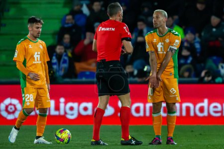 Foto de Madrid, Spain- January 28, 2023: Soccer match between Real Betis balonpie and Getafe F.C in Madrid. The players complain to the referee for a foul during the match. - Imagen libre de derechos