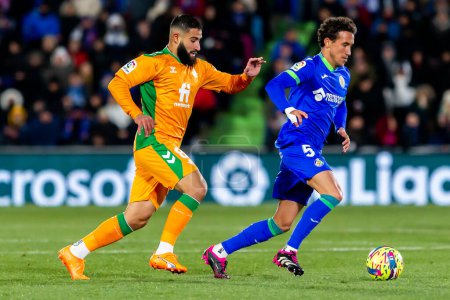 Foto de Madrid, Spain- January 28, 2023: Soccer match between Real Betis balonpie and Getafe F.C in Madrid. The Betis player Nabil Fekir fights with an opponent for the ball. - Imagen libre de derechos