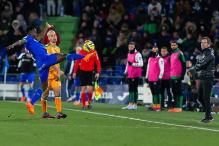 Foto de Madrid, Spain- January 28, 2023: Soccer match between Real Betis Balonpie and Getafe F.C in Madrid. The Getafe player  fights with an opponent for the ball. - Imagen libre de derechos