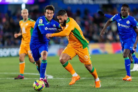 Photo for Madrid, Spain- January 28, 2023: Soccer match between Real Betis balonpie and Getafe F.C in Madrid. The Betis player Nabil Fekir fights with an opponent for the ball. - Royalty Free Image