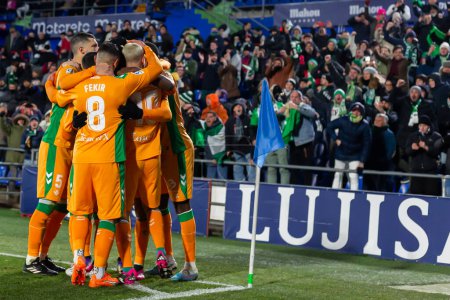 Foto de Madrid, Spain- January 28, 2023: Soccer match between Real Betis balonpie and Getafe F.C in Madrid. The Betis player Borja Iglesias celebrates a goal with his teammates and the fans. - Imagen libre de derechos