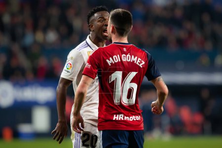 Téléchargez les photos : Madrid, Spain- February 18, 2023: League match between Real Madrid and Osasuna in Pamplona. Vinicius Jr. fights with an opponent. Football games. Real Madrid player. - en image libre de droit