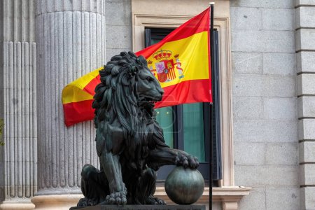 Téléchargez les photos : Madrid, Espagne - 31 octobre 2023 : Le Congrès des députés est décoré pour recevoir les rois d'Espagne et la princesse des Asturies le jour de leur anniversaire. Le lion des tribunaux à côté du drapeau de l'Espagne. - en image libre de droit