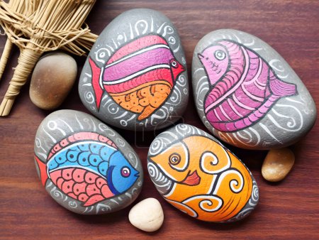 Photo for Painted round natural stones with fantasy tropical fishes - Royalty Free Image