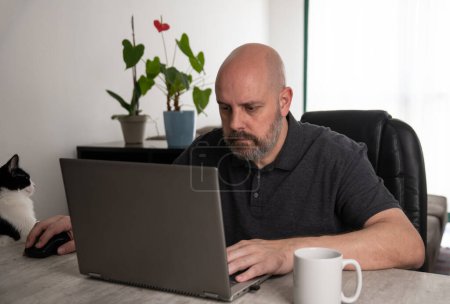Téléchargez les photos : Brésilien d'âge moyen à l'aide d'un ordinateur portable travaillant à la maison. - en image libre de droit