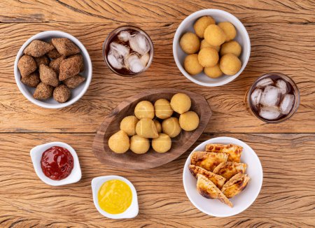 Photo for Coxinha, kibbeh, baked pastel and cheese balls, typical brazilian snacks. - Royalty Free Image