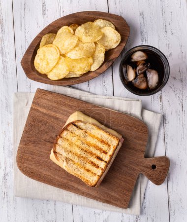 Téléchargez les photos : Sandwich au fromage et jambon avec croustilles et soda. - en image libre de droit